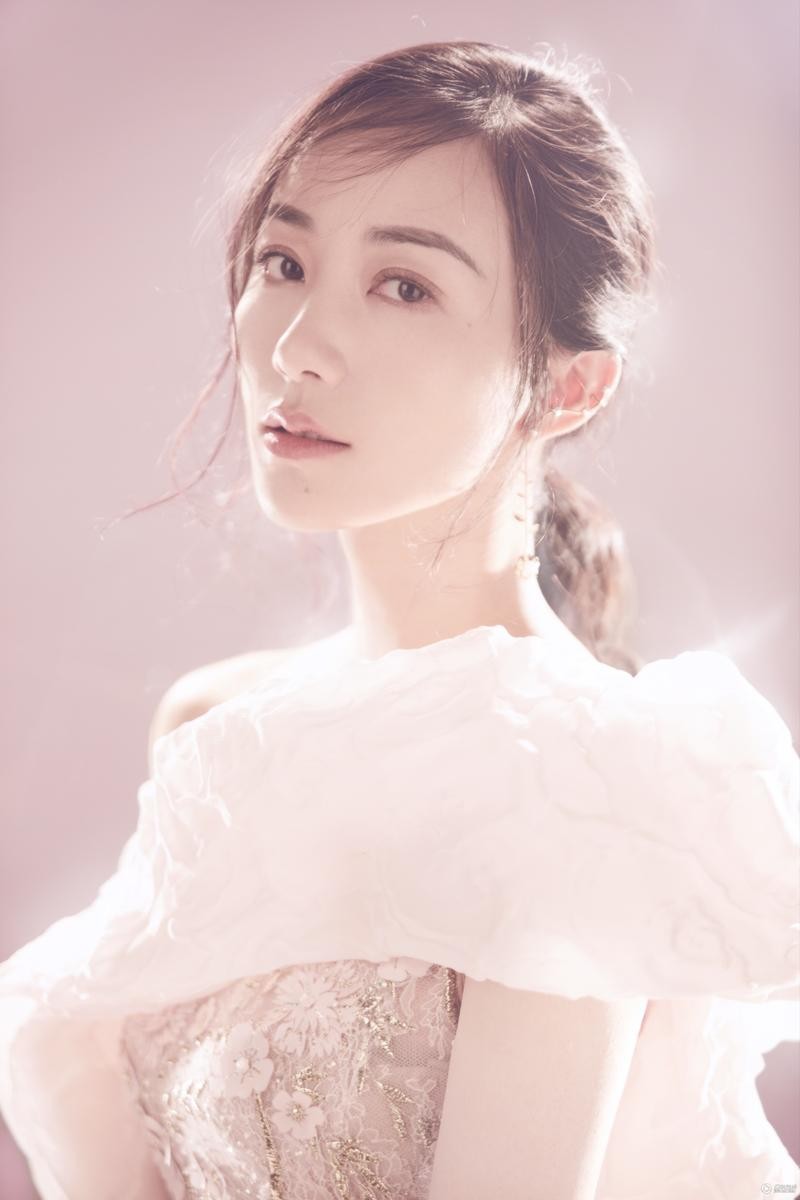 韩雪倚靠窗边，柔和光线勾勒其优雅侧颜，神情恬静若有所思，画面充满故事感与宁静的诗意。