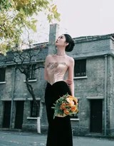 吴优微卷长发披肩，一手轻撩发丝，眼神自信眺望远方，红唇勾勒出迷人弧度