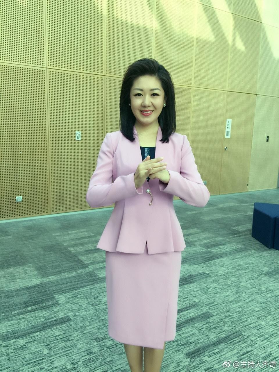 齐奇侧身优雅站立，肉色丝袜勾勒出腿部完美曲线，灯光下肌肤泛着柔和光泽