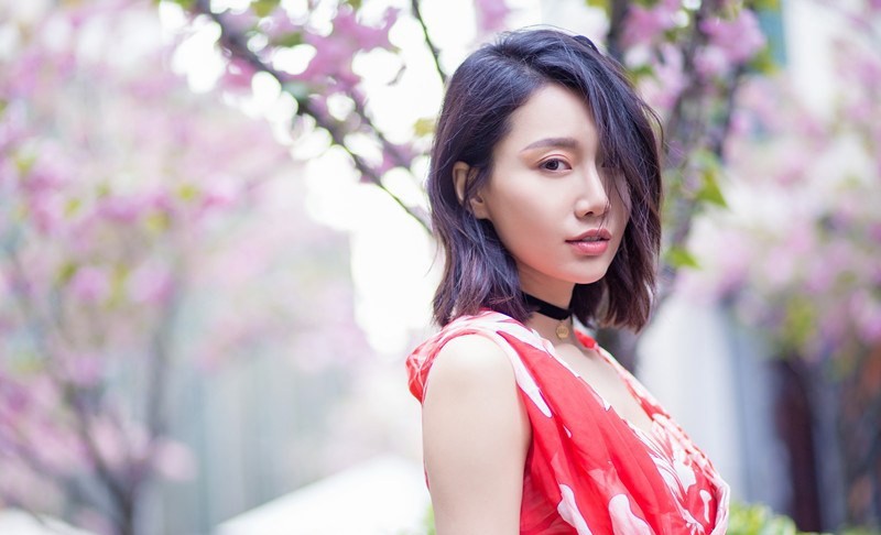 李斯羽于鲜花簇拥下闭目感受春日气息，画面宁静而充满生命力