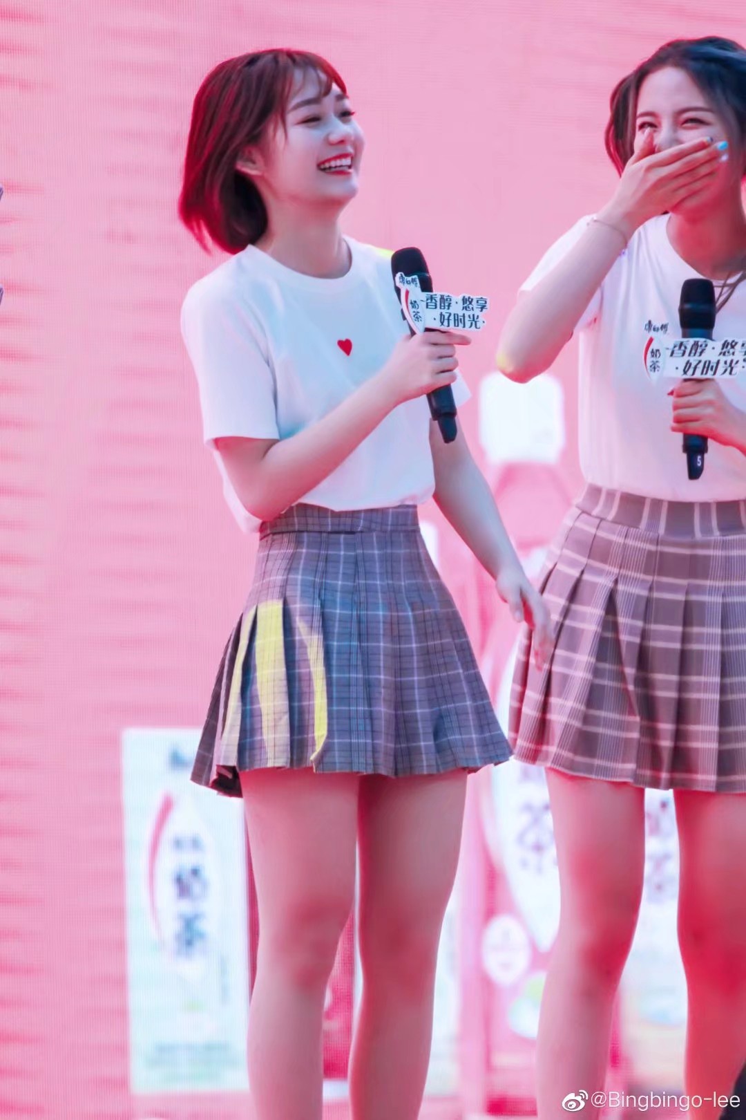 段奥娟手持麦克风深情演唱，舞台灯光洒落发梢